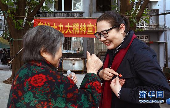 听完后,在场的一位聋哑人连忙拉住李龙梅,表达自己对党的感激之情。新华网 赵紫东 摄