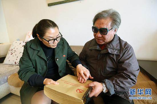 下班后的李龙梅来到张治平家中,将十九大报告盲文版送给这位退休盲人老师。新华网发