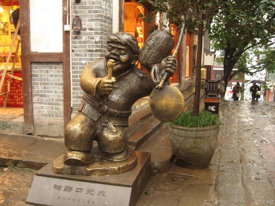 位于磁器口街头的更夫雕塑憨态可掬,深受游客喜爱,“更夫”左手举着灯笼,下面吊着一面锣,右手举着锣槌,就像是正在打更报时。