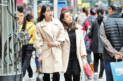 近日,行走在街头的市民也纷纷穿上厚厚的冬装,抵御阵阵寒意。本报记者 胡杰 摄