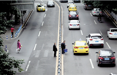 行人跨越马路中间隔离栏,今后将被抓拍