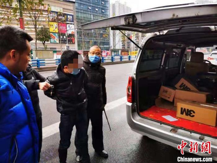 图为嫌疑人指认假冒品牌口罩。 警方供图 摄