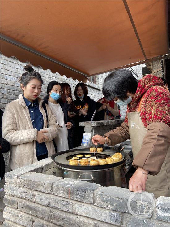 △市民在山城巷排队买小时候常吃的熨斗糕