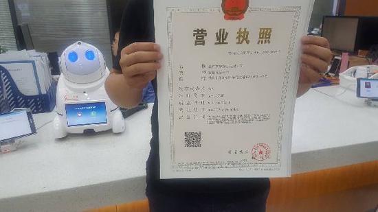 今日上午,九龙坡区首张“三十一证合一”营业执照正式发出。九龙坡区工商分局供图 华龙网发