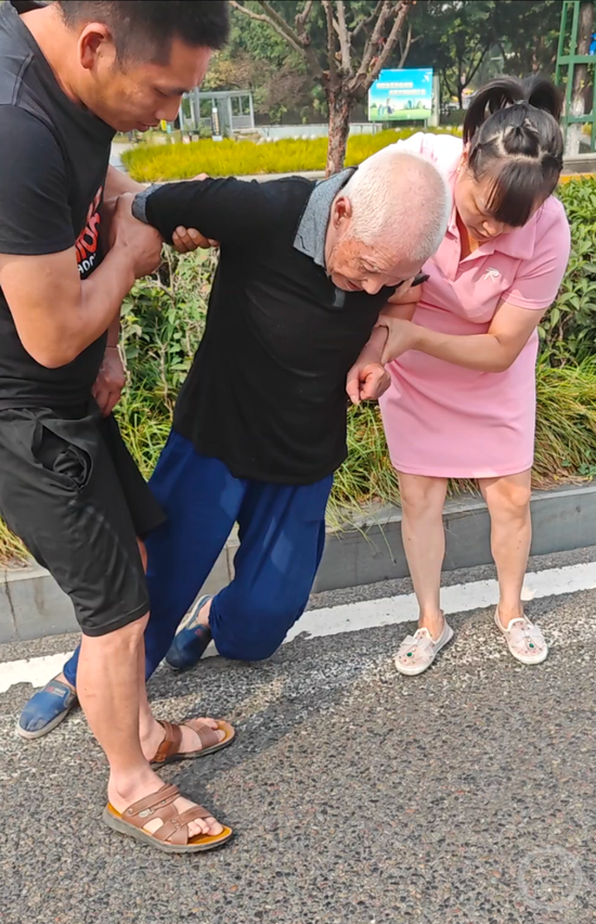 ▲两人从快车道扶起瘫倒老人。
