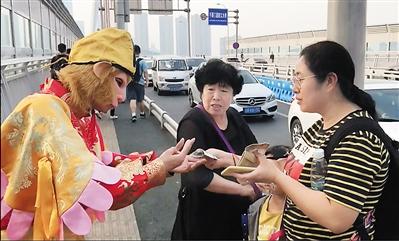 11日,“孙悟空”合影后伸手向游客要钱。 本报记者 李斌 摄