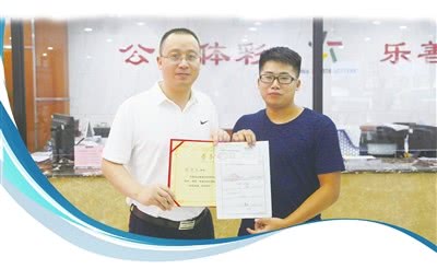 市体彩中心主任张小波(左)为大奖得主颁发足彩大奖与“中国体育彩票爱心使者”荣誉证书