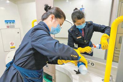 为应对疫情,铁路部门全力做好相关防控工作。图为南昌开往南京的G1496次列车上,南昌客运段工作人员认真做好车厢清洁、消毒工作。 鲍赣生摄(人民视觉)