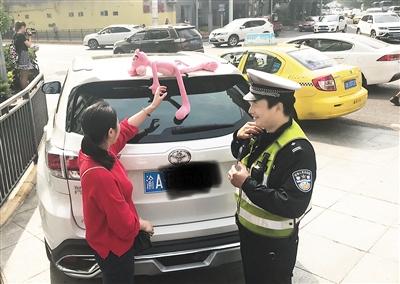 昨日,杨家坪,一辆白色车尾部车顶贴着一个“粉红豹”玩偶,被正在执勤的交巡警拦了下来。