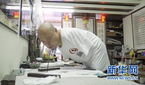黄国富正在作画。新华网 彭博 摄