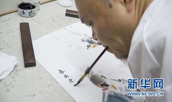 黄国富正在作画。新华网 彭博 摄