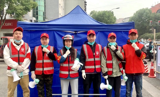 ▲吴朴慧（左三）和另外五名志愿者参与战疫志愿服务