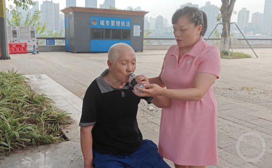 ▲给老人送上矿泉水解渴。