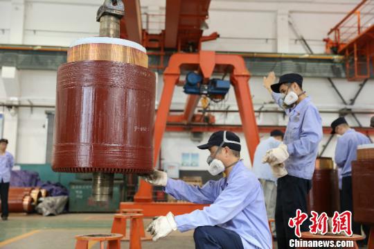 图为重庆机务段电枢组职工将烘焙了16小时候，温度达到达165℃至175℃的电枢吊到检修存放架上。　李富彬 摄