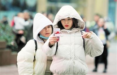 天气冷了,市民穿厚衣服逛街。