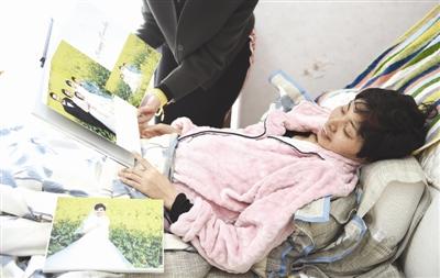 付建蓉躺在床上看照片 摄影记者 张士博