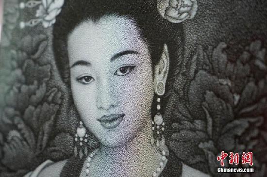 影雕作品上的人物全靠大小不一的凿点营造而成