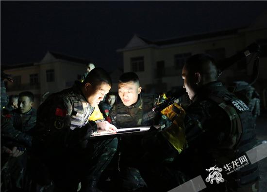 夜间,侦查队员在地图上判定方位找坐标。曹伟 摄