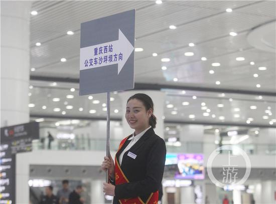 ca0119e25d24bf1892f5dc15f7c62d05.jpg △重庆西站,导引员在出站口举牌指路。