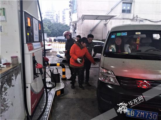 加油员赵伟向记者指明当初白色长安车加油的位置。记者张勇 摄