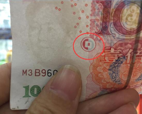 △透过光线,记者在便利店看到的这张假币形成的图案错位。