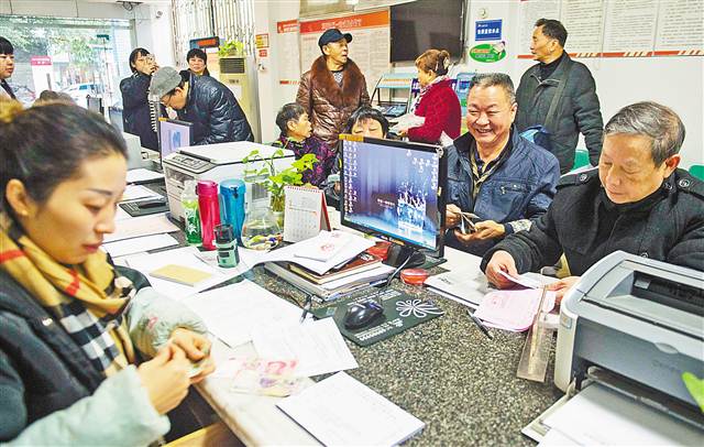 一月十五日,大渡口区跃进村街道革新社区,老年人在社区工作人员帮助下办理老年卡。