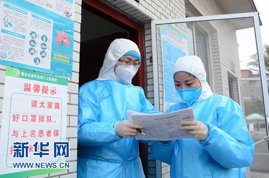 左丽(右)与医生核对发热病人基本情况登记表。新华网发(张常伟 摄)