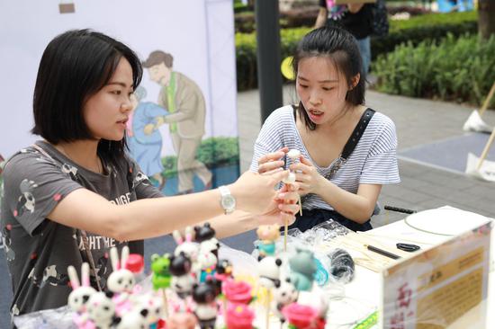 街道互动体验区,市民正在体验捏橡皮人活动