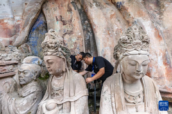 8月19日,在大足石刻宝顶山景区,工作人员对石刻造像病害进行处理。新华社记者 黄伟 摄
