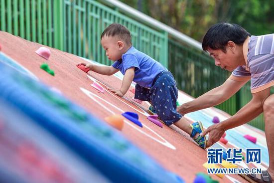 图为市民带着小孩在江北区赵家山体育文化公园玩耍。新华网 发(重庆市规划和自然资源局供图)