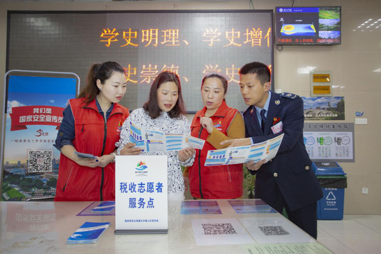 图:社区税收志愿者与“党员春风服务队”一道向纳税人解答涉税疑问(姜钟伟摄)