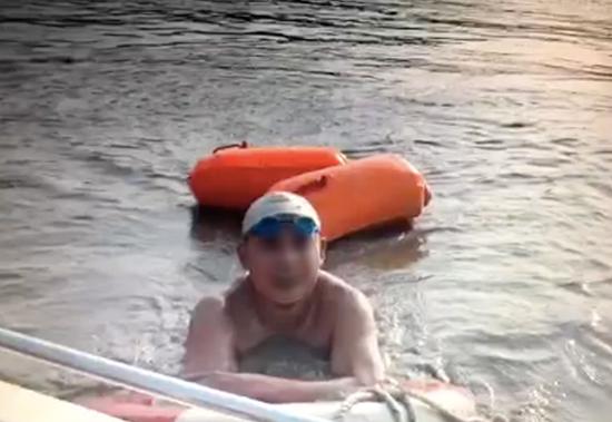 一名游泳者在洪水中漂流,并向救援的消防官兵介绍情况。 北碚消防支队供图 华龙网发