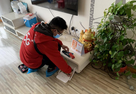 (中国移动重庆公司装维人员为客户安装家庭宽带)