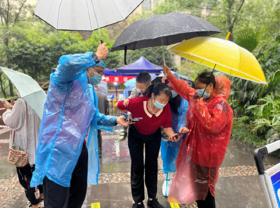 金山街道金渝社区爱加西西里采样点，志愿者帮带孩子的居民打伞。（金渝社区供图）