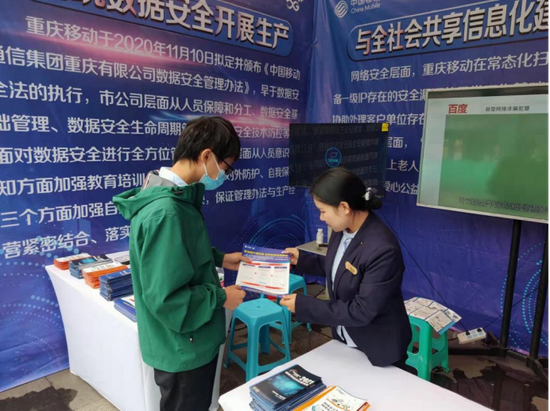 (重庆移动工作人员向市民发送网络安全知识宣传页)