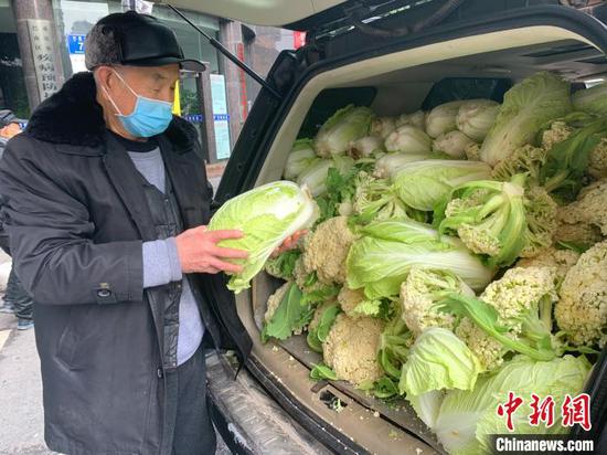 图为徐先恒老人送蔬菜。 钟欣 摄