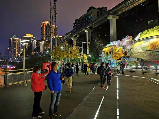 李子坝列车穿楼夜景再升级 炫酷列车追着光跑[组图]