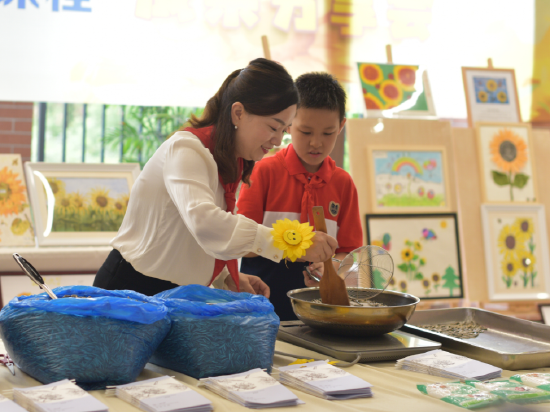 学生参与葵花籽炒制。(星湖学校供图)