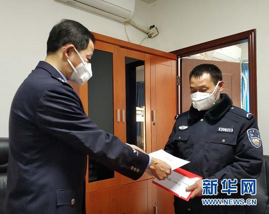 渝北交巡警支队龙溪大队教导员王世平(左)给段辉富发放强制陪护通知书和捐款。新华网 陈雨 摄