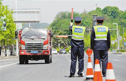 4月13日,在南岸区通江大道建筑垃圾密闭运输检查点,市政执法人员正在检查运渣车辆