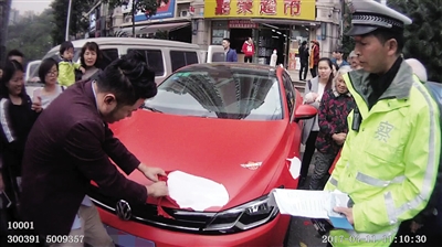 一车主因擅自改变车身颜色,被责令当场除去车辆“外衣”。 九龙坡警方供图