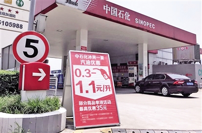 昨日，菜园坝一家加油站打出汽油优惠0.3一1.1元/升的广告牌。 本报记者 杨新宇 摄