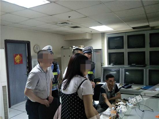 民警帮助报警人调取查看当事电影院的监控录像。记者 张勇 摄