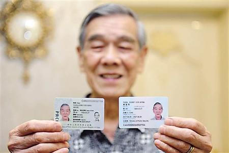 袁先生在展示拿到的重庆首张新版外国人永居证