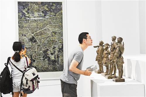 8月1日,在重庆美术馆,观众正在欣赏展出的美术作品。