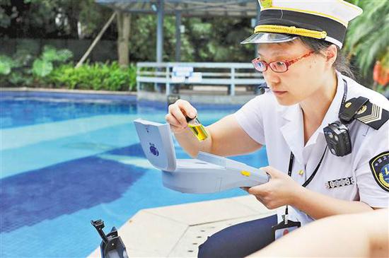 8月10日,在融汇5期游泳池,执法人员正对游泳池水质指标进行现场快检