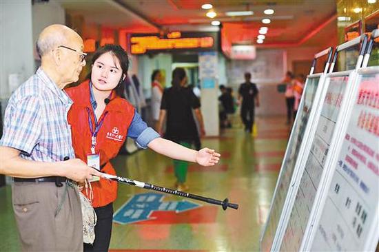 9月9日,在市人民医院,一位志愿者正在给患者讲解新政策。 记者 李珩 摄