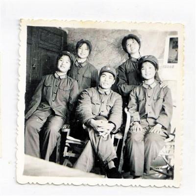 40年前几个女孩和谢干事的合照,一排中间为谢干事。受访者供图