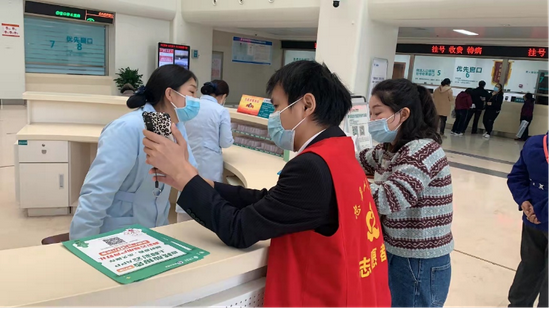 (院方志愿者为核酸检测人员介绍“和彩云”便捷使用方式)