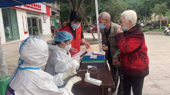 ▲段启芳、龙美在核酸检测点老弱病残通道协助信息查验